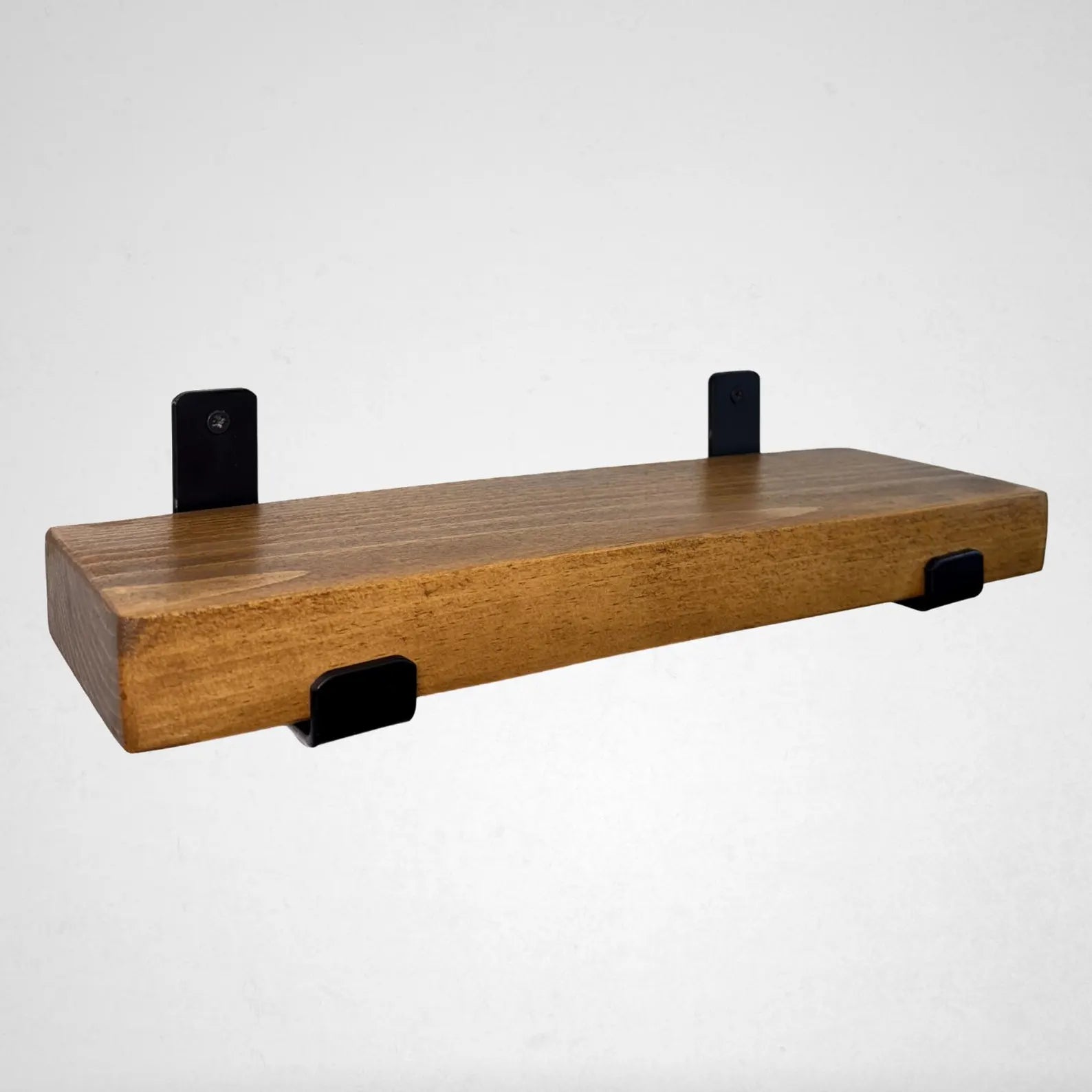 Wooden shelf with black brackets on a white background