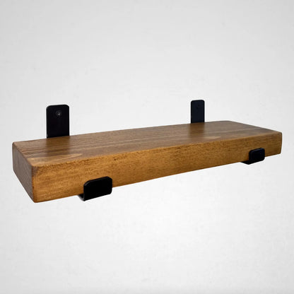 Wooden shelf with black brackets on a white background